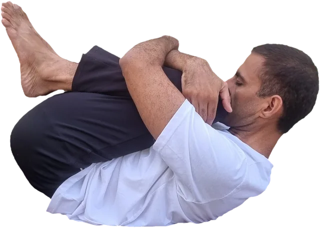 Sohan lying on his back, both arms hugging his knees to his chest, eyes closed and calm