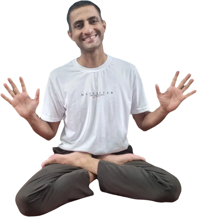 Sohan seated cross-legged, smiling, with both palms open in welcome