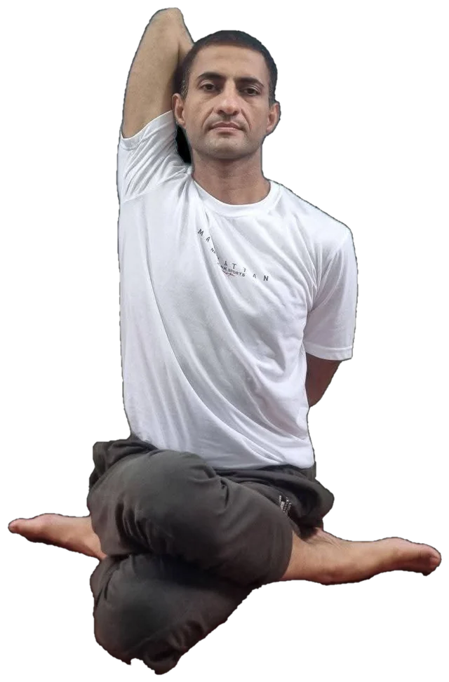 Sohan seated cross-legged, one arm raised behind his head, looking calmly at the camera
